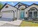 Close up of home's facade, light fixtures, blue front door, and well manicured lawn at 868 Shell Ln, Longwood, FL 32750