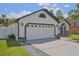 Garage door and front facade of a single Gathering home with well manicured lawn at 868 Shell Ln, Longwood, FL 32750
