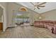 Living room featuring wood floors, ceiling fan, leather couch, and sliding glass doors to backyard at 868 Shell Ln, Longwood, FL 32750