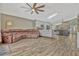 Living room featuring wood floors, leather couch, ceiling fan, and view of the kitchen at 868 Shell Ln, Longwood, FL 32750