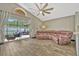 Open concept living room featuring a large leather couch, ceiling fan, and sliding glass door to backyard at 868 Shell Ln, Longwood, FL 32750