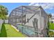 A screened-in pool features decorative cacti and artificial turf for easy outdoor relaxation and entertaining at 868 Shell Ln, Longwood, FL 32750