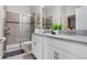 Modern bathroom with walk-in shower, double sink vanity with white cabinets and stone countertops at 8816 Cruden Bay Ct, Davenport, FL 33896