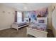 Bright bedroom with two beds, purple curtains, and a mural fit for a fairytale at 8816 Cruden Bay Ct, Davenport, FL 33896