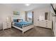 Bright bedroom featuring a queen size bed, a dresser, and a bedside table with a lamp at 8816 Cruden Bay Ct, Davenport, FL 33896