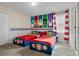 A twin bedroom offers superhero-themed decor, striped curtains, and ample natural light at 8816 Cruden Bay Ct, Davenport, FL 33896
