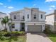Modern two-story home featuring stone accents, a two-car garage, and a well-maintained front yard at 8816 Cruden Bay Ct, Davenport, FL 33896