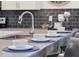 Close-up of a sleek kitchen bar with seating, featuring a modern faucet and neutral color palette at 8816 Cruden Bay Ct, Davenport, FL 33896