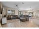 Spacious living room with sectional sofa, tile floors, decorative wall art and seamless flow to dining area at 8816 Cruden Bay Ct, Davenport, FL 33896