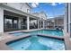 Beautiful screened-in pool area with a spa, spacious patio, and clear blue water at 8816 Cruden Bay Ct, Davenport, FL 33896