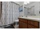 Bathroom with a modern vanity, framed mirror, and shower with a patterned curtain at 9235 Everwood St, Orlando, FL 32825