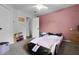 bedroom features a pink race car bed, pink accent wall, and neutral carpet at 9235 Everwood St, Orlando, FL 32825