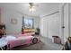 A bedroom with a ceiling fan, dresser, closet, and a pink race car bed at 9235 Everwood St, Orlando, FL 32825