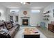Cozy living room featuring a stone fireplace, modern furnishings, and lots of natural light at 9235 Everwood St, Orlando, FL 32825