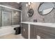 This modern bathroom features sleek dual vanities and a shower, all adorned with a stylish gray textured wall at 442 Flora Creek Ct, Lake Mary, FL 32746