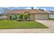 Charming single-story home with a well-manicured lawn and verdant landscaping at 1002 Ohanlon Ct, Oviedo, FL 32765