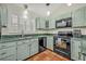 Galley kitchen offers ample counter space, black appliances, tile floors, and a window above the sink at 1002 Ohanlon Ct, Oviedo, FL 32765