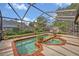 A screened-in pool features brick trim, with mature landscaping outside the enclosure at 1002 Ohanlon Ct, Oviedo, FL 32765