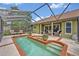 A screened-in pool boasts red brick trim, lounge chairs and steps for hot tub access at 1002 Ohanlon Ct, Oviedo, FL 32765