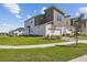 Contemporary townhome features manicured lawns, a two-car garage, and neutral two-tone exterior paint at 1195 Boardwalk Pl, Kissimmee, FL 34747