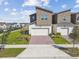 Modern townhome boasts a brick-paved driveway, a two-car garage, and well-maintained landscaping at 1195 Boardwalk Pl, Kissimmee, FL 34747