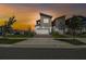 Modern two-story home with attached garage and manicured lawn at sunset at 1195 Boardwalk Pl, Kissimmee, FL 34747