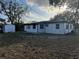 Spacious backyard featuring a storage shed, bordered by trees, and partial view of the home at 1289 E Hancock Dr, Deltona, FL 32725
