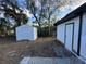 View of the backyard featuring two white sheds and partial view of a home at 1289 E Hancock Dr, Deltona, FL 32725