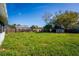 Lush backyard featuring a green lawn, a wooden fence, and a storage shed, perfect for outdoor activities at 1315 Overdale St, Orlando, FL 32825