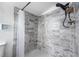 Bathroom shower featuring modern gray marble tiling, shower caddy and decorative nautical-themed wall art at 1315 Overdale St, Orlando, FL 32825