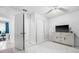 Bright bedroom with tiled floors, a TV on a cabinet, and white walls with matching doors at 1315 Overdale St, Orlando, FL 32825