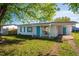 Charming single-story home with a vibrant blue door and shutters, complemented by a well-manicured lawn at 1315 Overdale St, Orlando, FL 32825