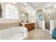 Luxurious bathroom featuring a soaking tub, a walk-in shower, and dual sinks at 14318 Fieldstone Lake Way, Orlando, FL 32824