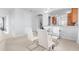 Dining room with a glass dining table and modern chairs, next to open archway to the kitchen at 14318 Fieldstone Lake Way, Orlando, FL 32824