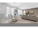 Dining room with a glass table, modern white chairs, and view of living room and tv at 14318 Fieldstone Lake Way, Orlando, FL 32824