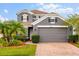 Charming two-story home with a brick driveway, mature landscaping, and a gray exterior paint at 14318 Fieldstone Lake Way, Orlando, FL 32824