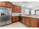 Well-equipped kitchen featuring stainless steel appliances, wood cabinetry, and an open view to the dining area at 14318 Fieldstone Lake Way, Orlando, FL 32824