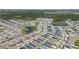 A high-definition aerial view of a neighborhood featuring modern homes, a community pool, and tranquil ponds surrounded by lush greenery at 1575 Eucalyptus Way, Davenport, FL 33837
