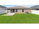 Well-maintained backyard featuring lush green grass, a white fence, and a screened lanai at 1575 Eucalyptus Way, Davenport, FL 33837