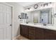 Bathroom with a double sink vanity with dark wood cabinets and door to the bedroom at 1575 Eucalyptus Way, Davenport, FL 33837