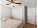 A clean bedroom features a ceiling fan, a closet, a bed with a patterned comforter and carpet at 1575 Eucalyptus Way, Davenport, FL 33837