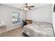 A bedroom features a bed, desk, chair, ceiling fan, and a window with blinds at 1575 Eucalyptus Way, Davenport, FL 33837
