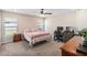 Spacious carpeted bedroom featuring a ceiling fan, a large window, and a functional desk area at 1575 Eucalyptus Way, Davenport, FL 33837