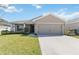 Charming single-story home with a well-manicured lawn, a two car garage and neutral colored exterior at 1575 Eucalyptus Way, Davenport, FL 33837