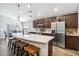 Stylish kitchen featuring a breakfast bar, modern stainless steel appliances, and pendant lighting at 1575 Eucalyptus Way, Davenport, FL 33837