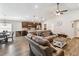 Open living space with wood-look floors, a dining area, and a kitchen island with seating at 1575 Eucalyptus Way, Davenport, FL 33837