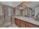 Bathroom featuring dual sinks, tiled shower with glass door, and vanity with storage at 174 Yellow Snapdragon Dr, Davenport, FL 33837