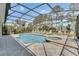 Enclosed pool area featuring a large pool, jacuzzi, tile flooring, and ample seating at 174 Yellow Snapdragon Dr, Davenport, FL 33837