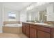 Bathroom featuring a large mirror, dual sinks, and a soaking tub at 1893 Rafton Rd, Apopka, FL 32703