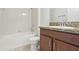 Bright bathroom with a tub and shower combo, featuring a vanity with a granite countertop at 1893 Rafton Rd, Apopka, FL 32703